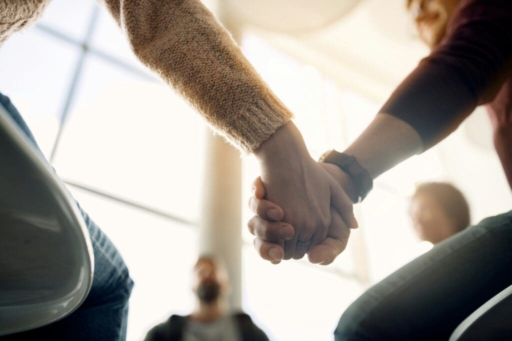 a close up of two people holding hands, symbolizing support and connection in mental health care in New Jersey