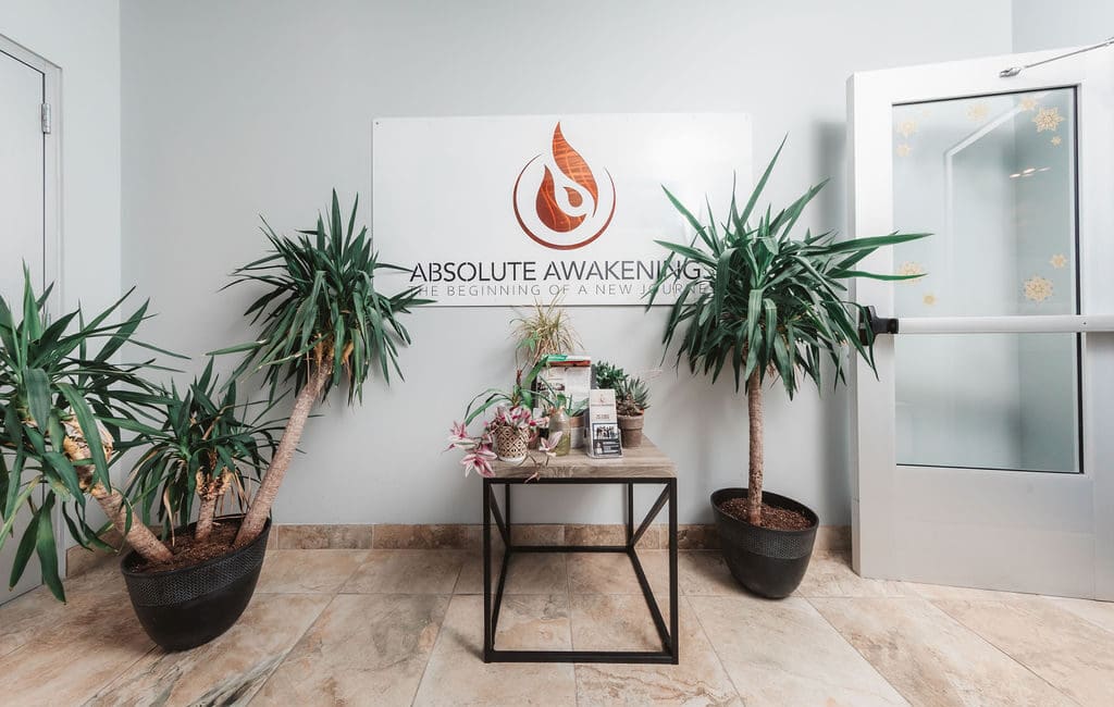 a room in a Mental Health Center Near New Jersey featuring a sign and two potted plants