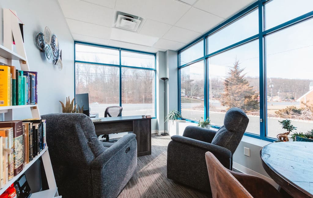 a living room filled with furniture and a large window, ideal for a Mental Health Center Near New Jersey