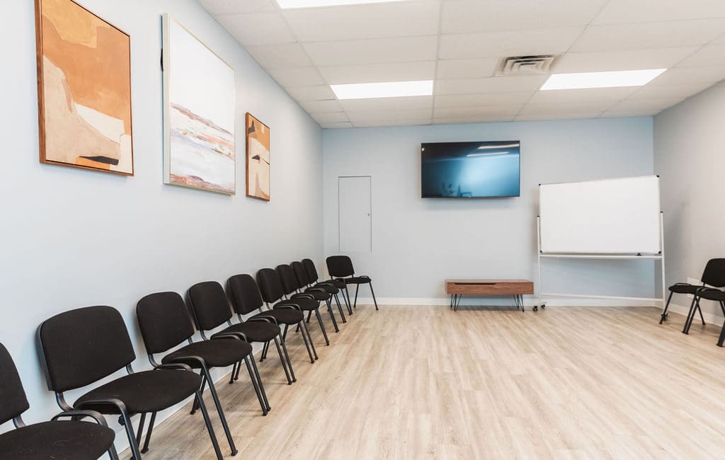 a room with chairs and a projector screen in a Mental Health Center Near New Jersey